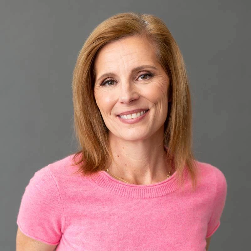 Headshot of Christal Goetz, Vice President of Blue Star Design Build in pink shirt.
